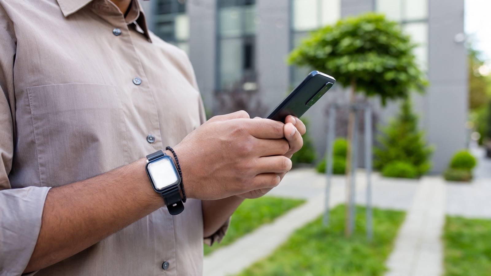 Hand holding a phone, checking an app