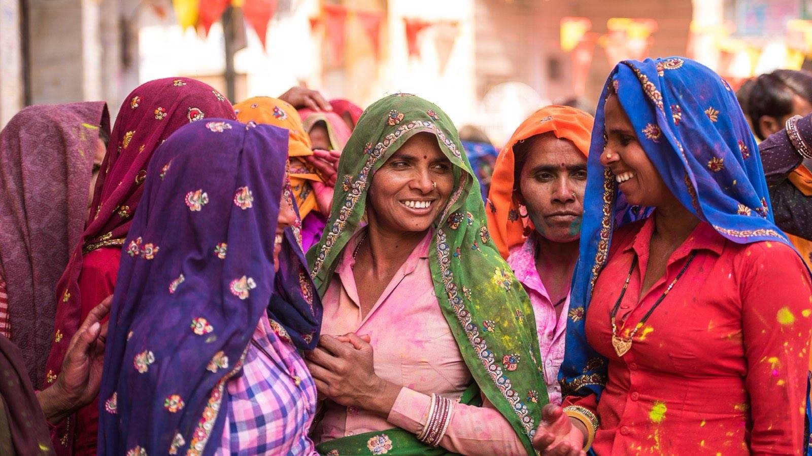 Group of women in colourful saris talking together outdoors