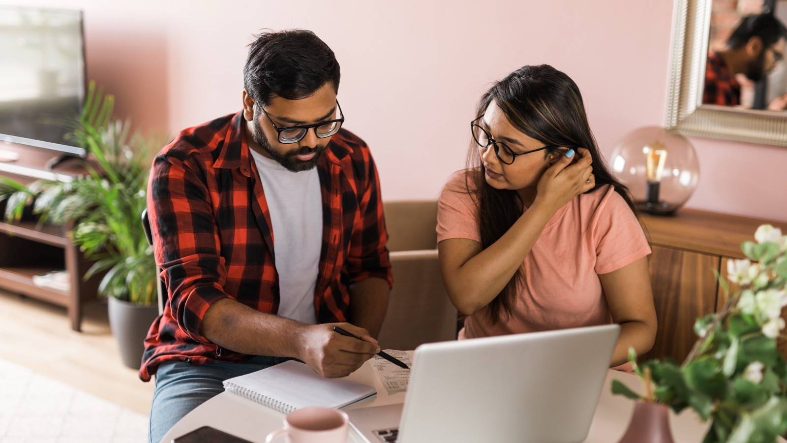 Couple going over papers together at a table at home